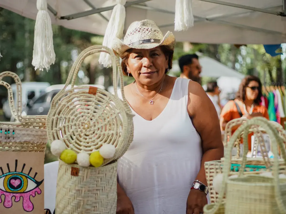 Señora con sus bolsas tejidas y artesanías en un bazar