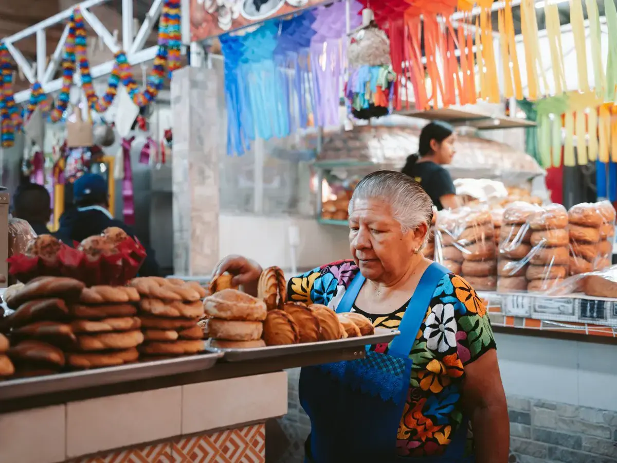 Vendedora acomodando pan en su puesto del mercado